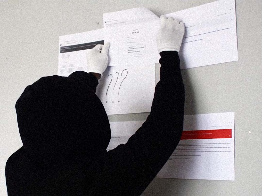 A figure in white gloves pinning printed documents to a wall.