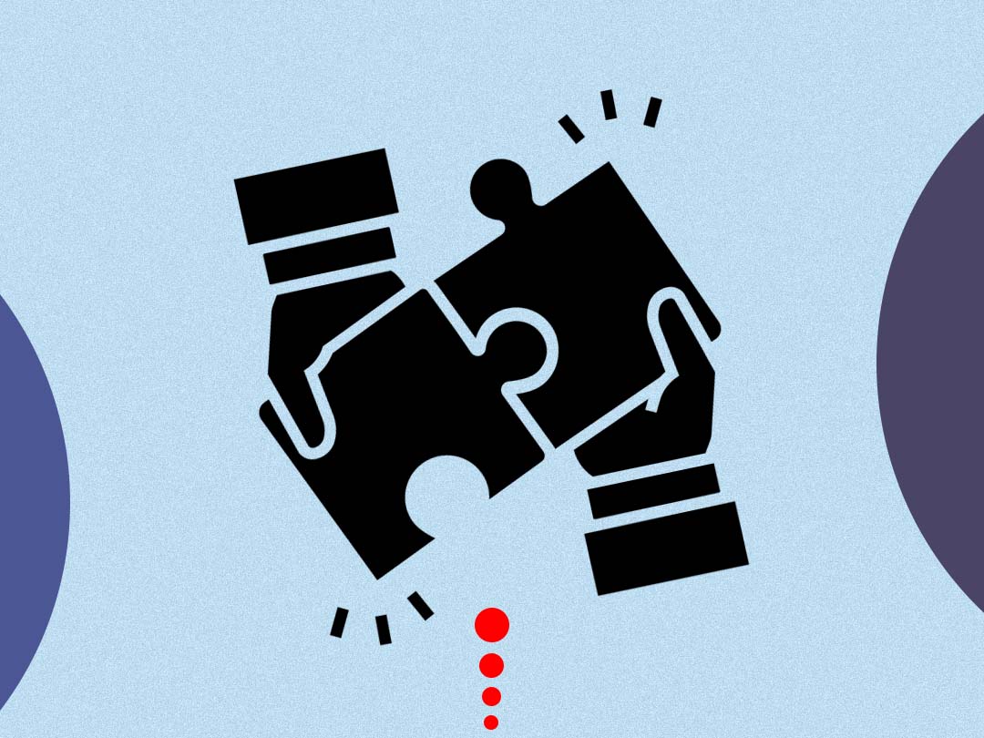 Two hands joining a pair of puzzle pieces.